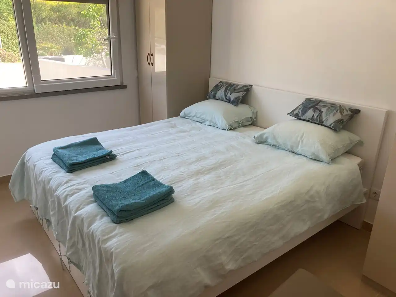 De slaapkamer op de begane grond is voorzien van een ruim tweepersoonsbed met twee afzonderlijke matrassen, een topper en een donzen dekbed. Daarnaast twee hang/legkasten met een ladenblok erin. 