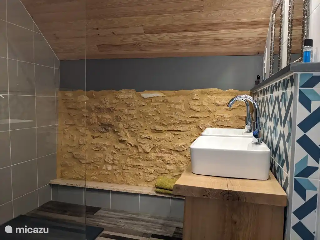 De badkamer op de eerste etage voorzien van inloopdouche en dubbele wastafel.