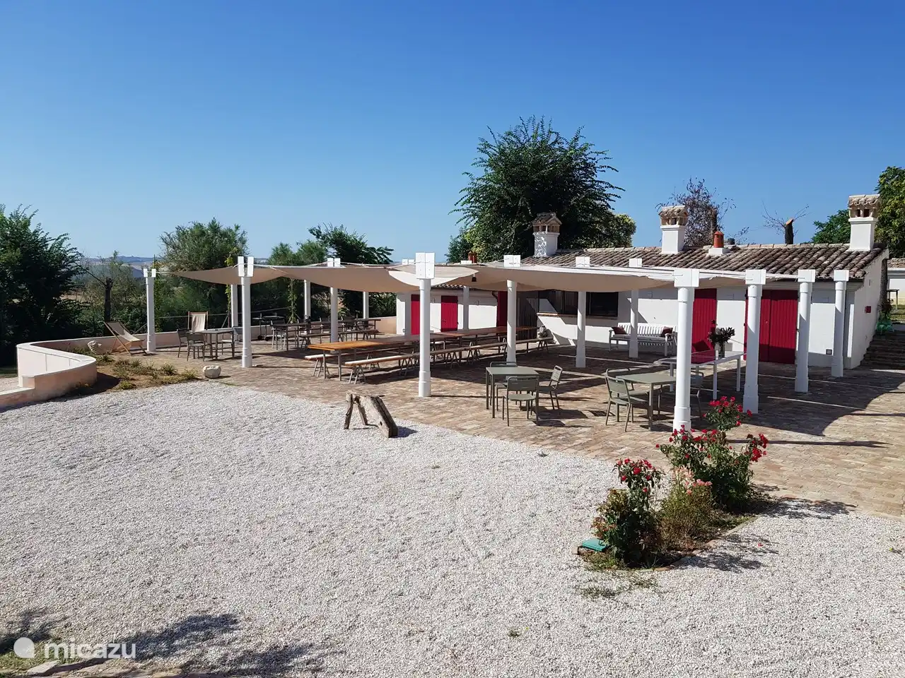 Pergola mit viel Schatten, langen Tischen, Toiletten, Umkleideraum und Gemeinschaftswaschraum. Unsere Outdoor-Küche ist das Herzstück der Themenabende.