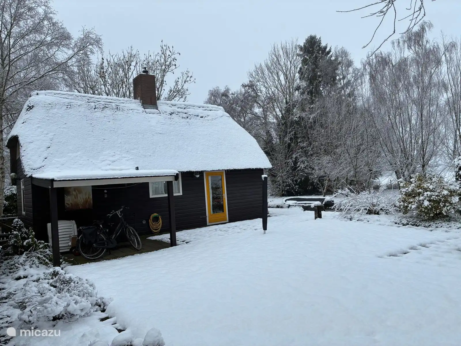 Huisje en tuin na sneeuwval.