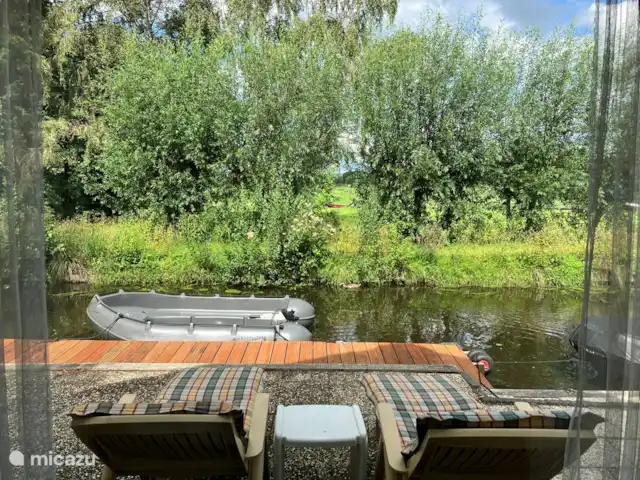 Oasis Giethoorn en Países Bajos, Overijssel, Giethoorn - casa rural / cabaña Vista desde el salón sobre el foso privado por donde pasan nadando los patos y más allá, detrás de los árboles, el Dorpsgracht por donde pasan los barcos.