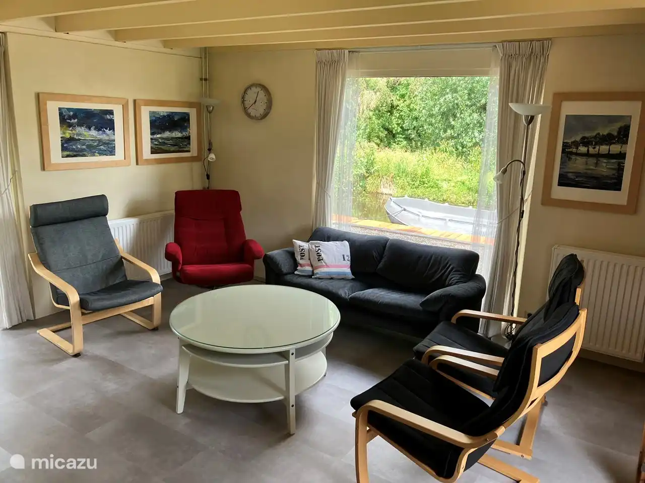 Gezellige ruime woonkamer met veel lichtinval, tuindeur, bank, 4 luie stoelen, speelgoed, spelletjes, boeken, radio, televisie, dvd-speler, dvd's en een prachtig uitzicht over het vaarwater en de weilanden.