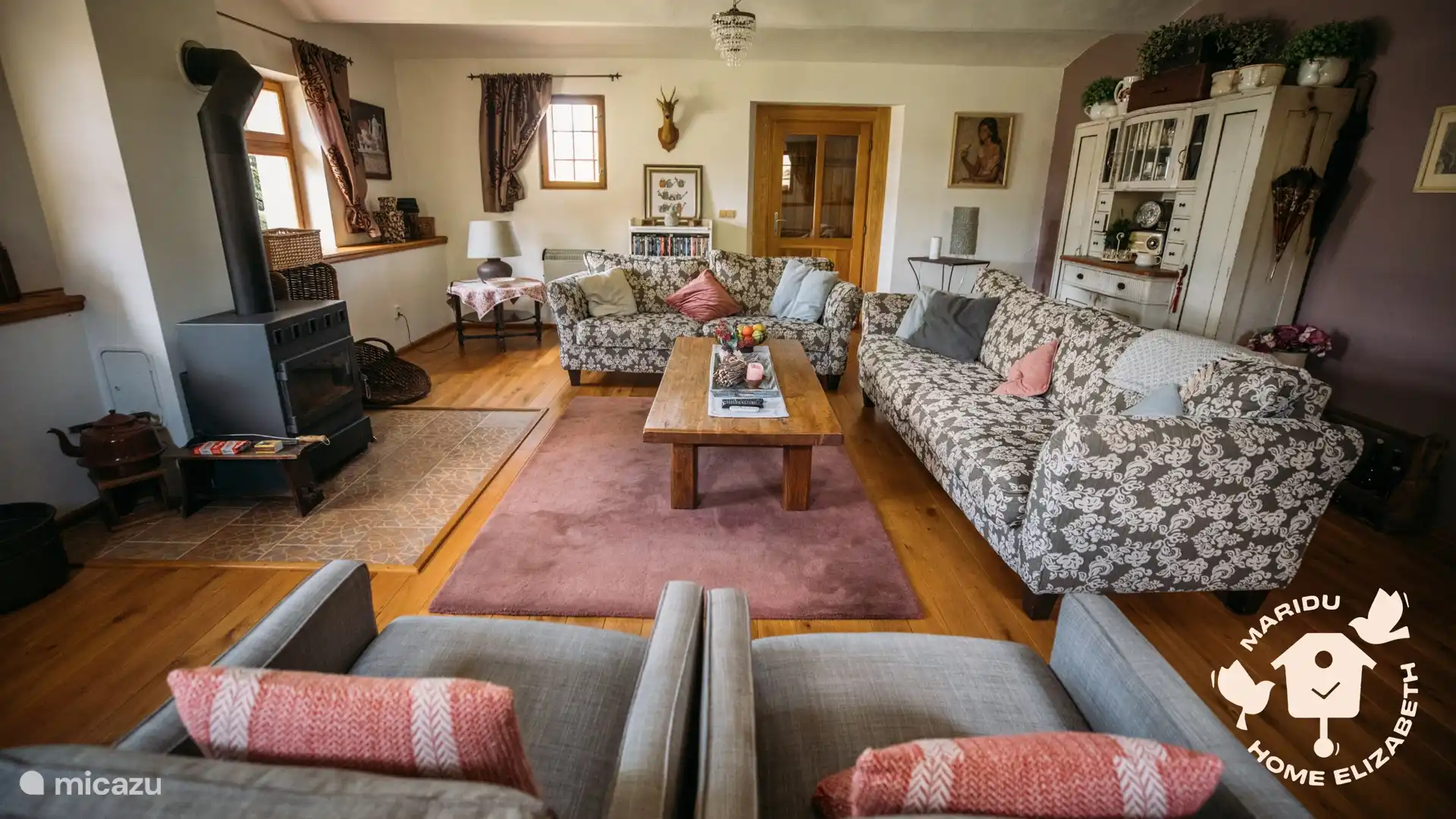 Ein warmes, gemütliches Wohnzimmer mit Holzofen und bequemen Sitzgelegenheiten – der ideale Ort, um sich nach einem Tag im Freien gemeinsam zu entspannen.