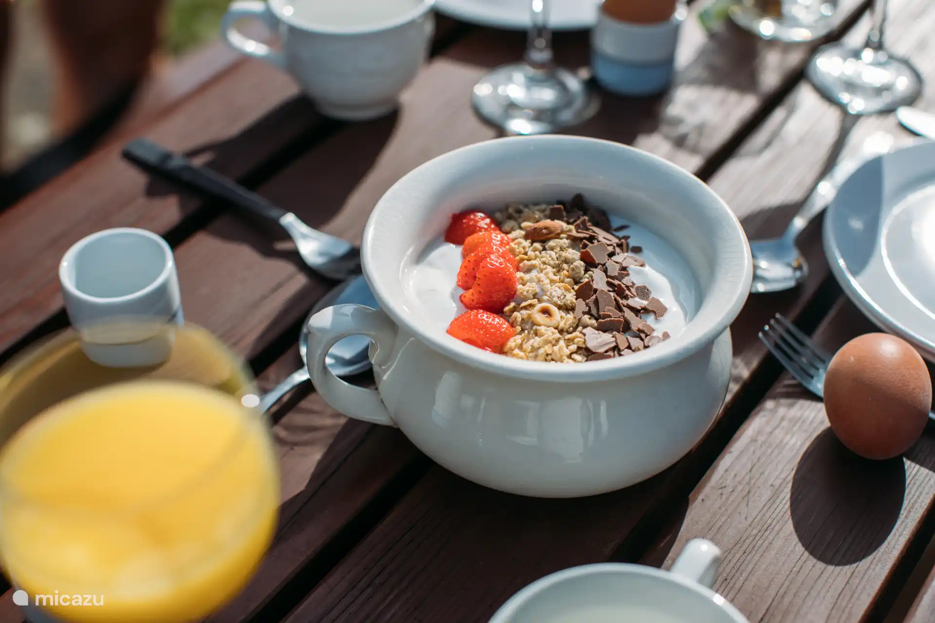 Beginnen Sie Ihren Tag mit einem frischen Frühstück in der Morgensonne – cremiger Joghurt, knuspriges Müsli und süße Erdbeeren auf der Terrasse des Holiday Home Elizabeth.