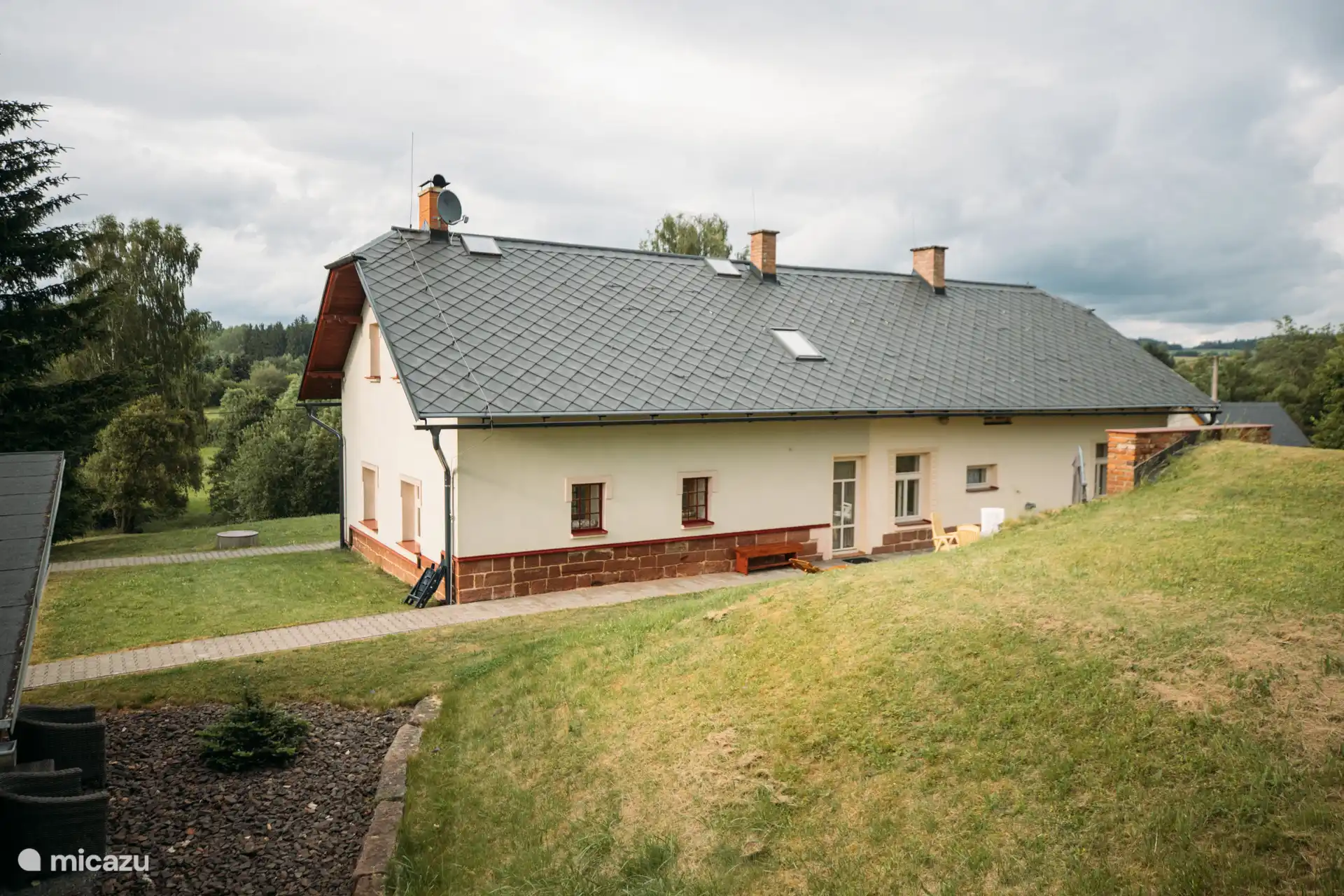 Der sonnige Hinterhof des Home Elizabeth mit direktem Zugang zur Terrasse und Blick auf die grünen Hügel der Tschechischen Republik.