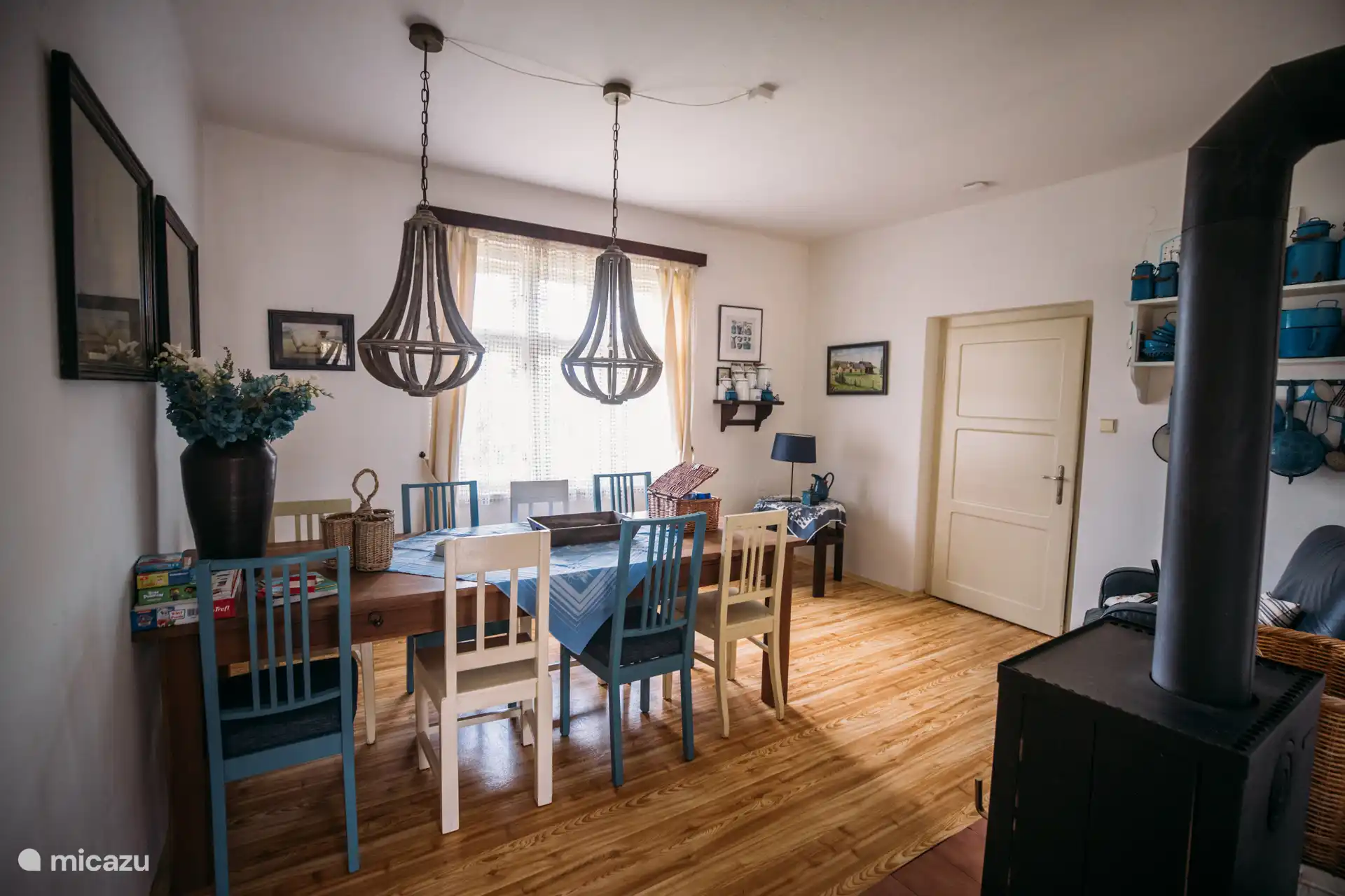 Geräumiges Esszimmer mit Holzofen, langer Tafel und gemütlichen Details – ideal für lange Abendessen, Spiele und warme Abende mit der ganzen Familie.