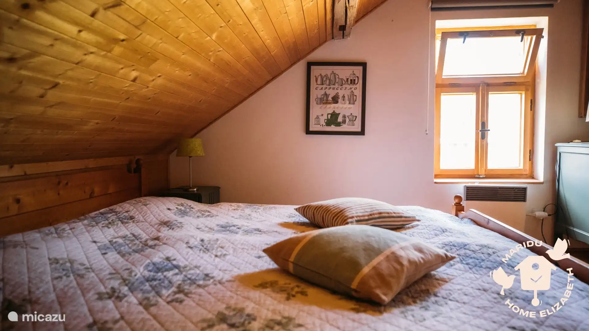 Gemütliches Dachgeschosszimmer mit Holzdecke und sanfter Morgensonne – ein warmes Plätzchen zum Entspannen.