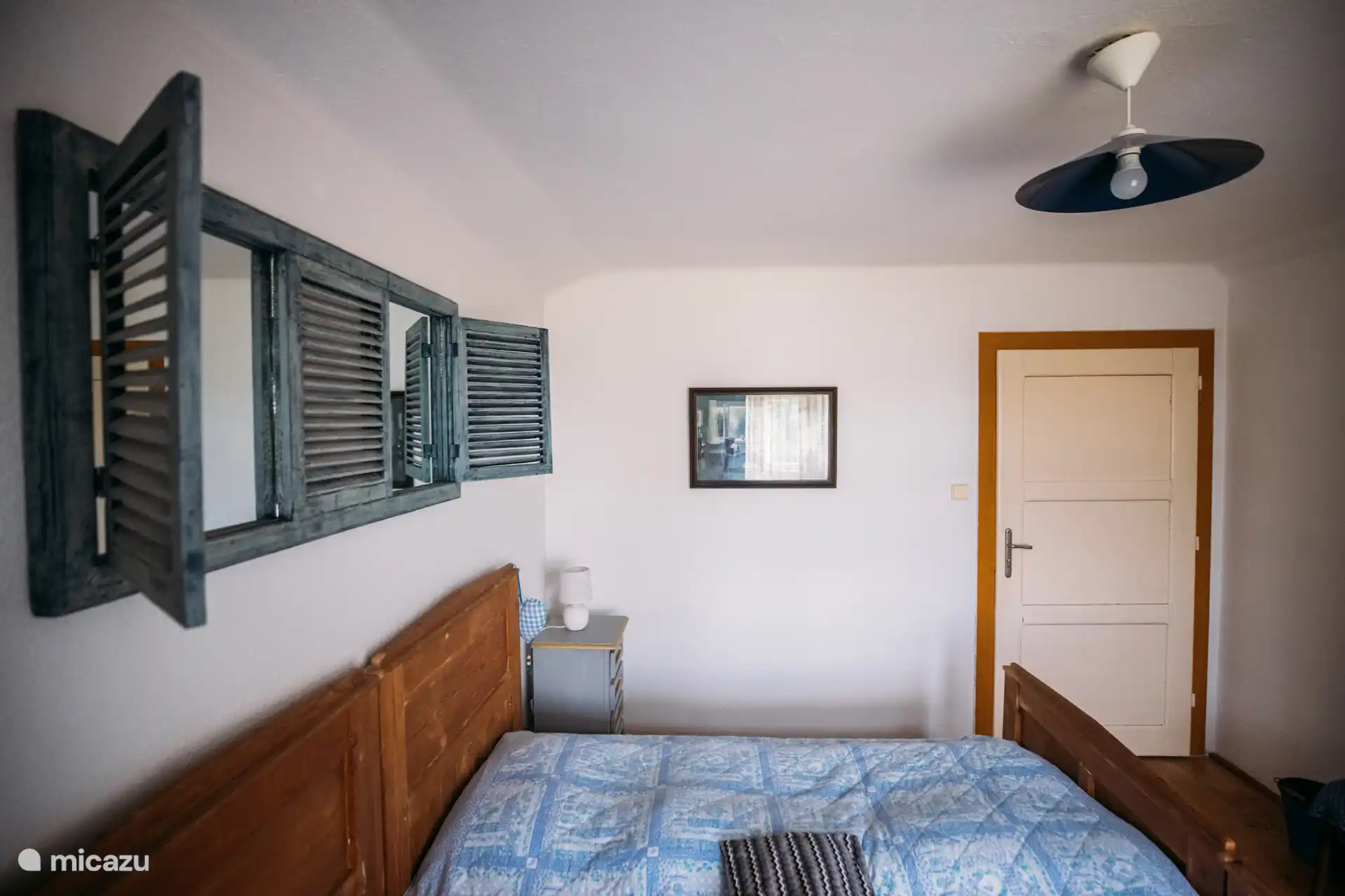 Gemütliches Schlafzimmer mit authentischen Details und einer beruhigenden blauen Farbpalette – perfekt für einen erholsamen Schlaf in ländlicher Stille.