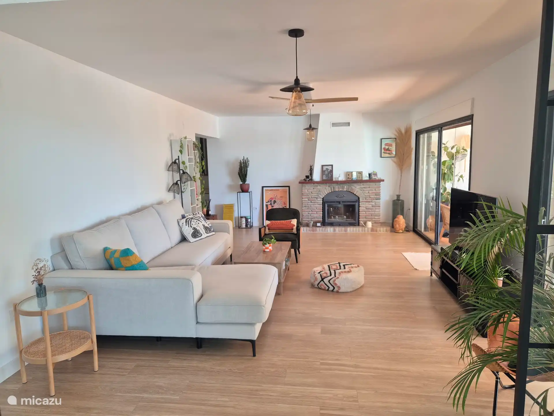 The living room is equipped with a spacious sofa with chaise longue, two separate armchairs and a 55 TV.