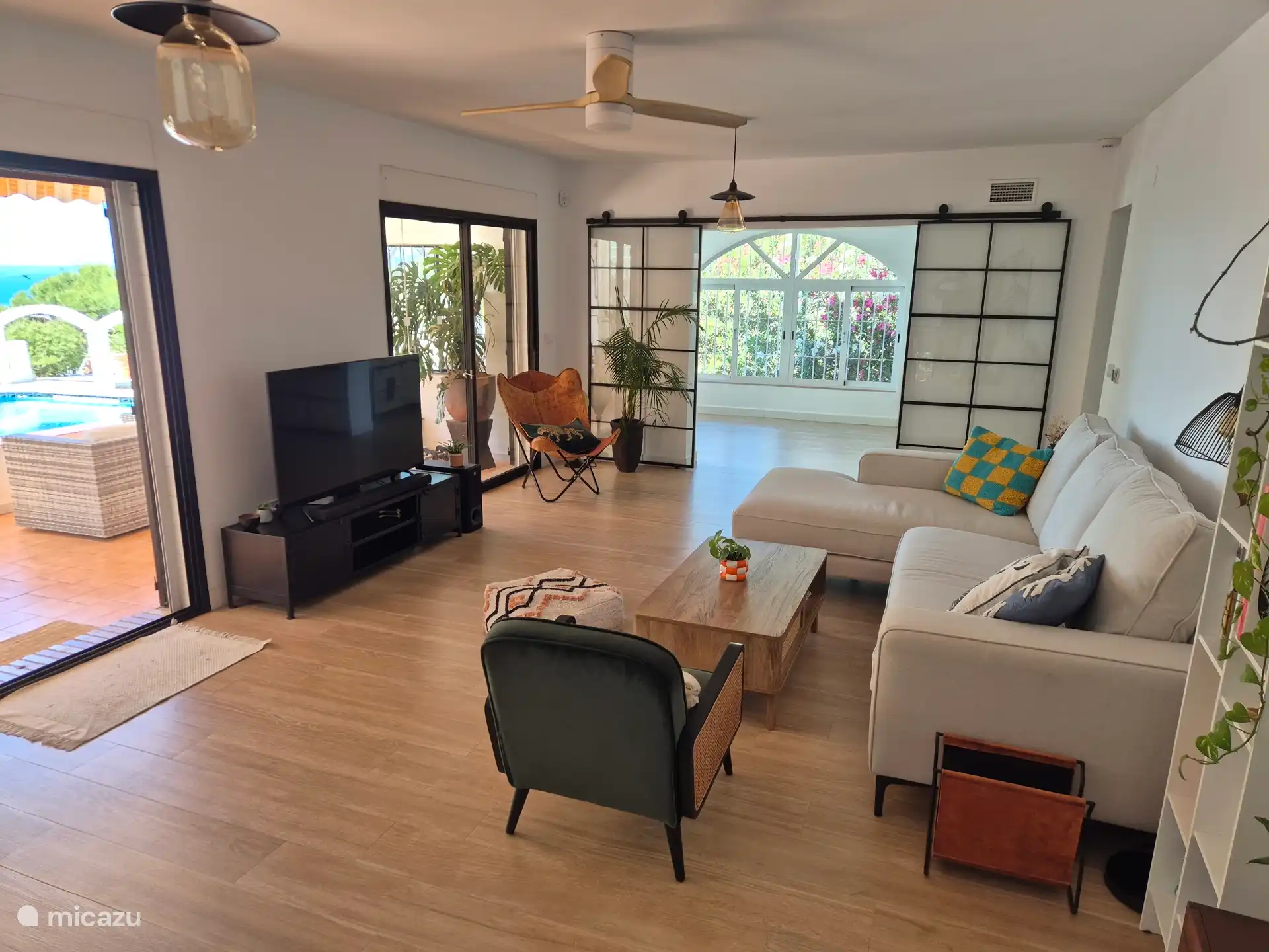 The living room is equipped with a spacious sofa with chaise longue, two separate armchairs and a 55 TV.