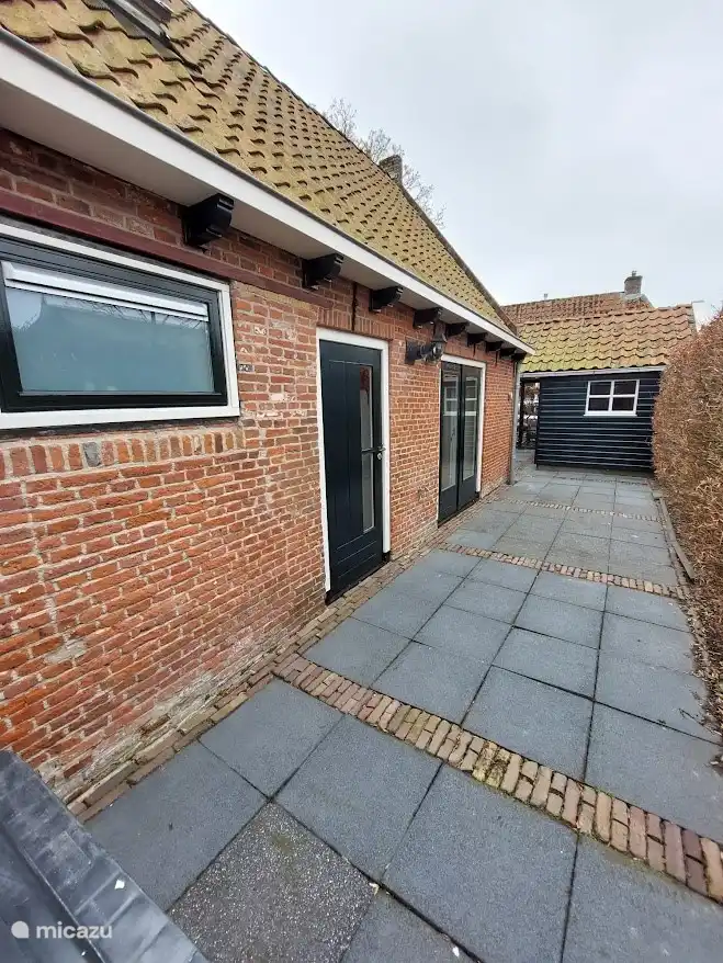 Terrasse hinter dem Haus, mit Terrassentüren.