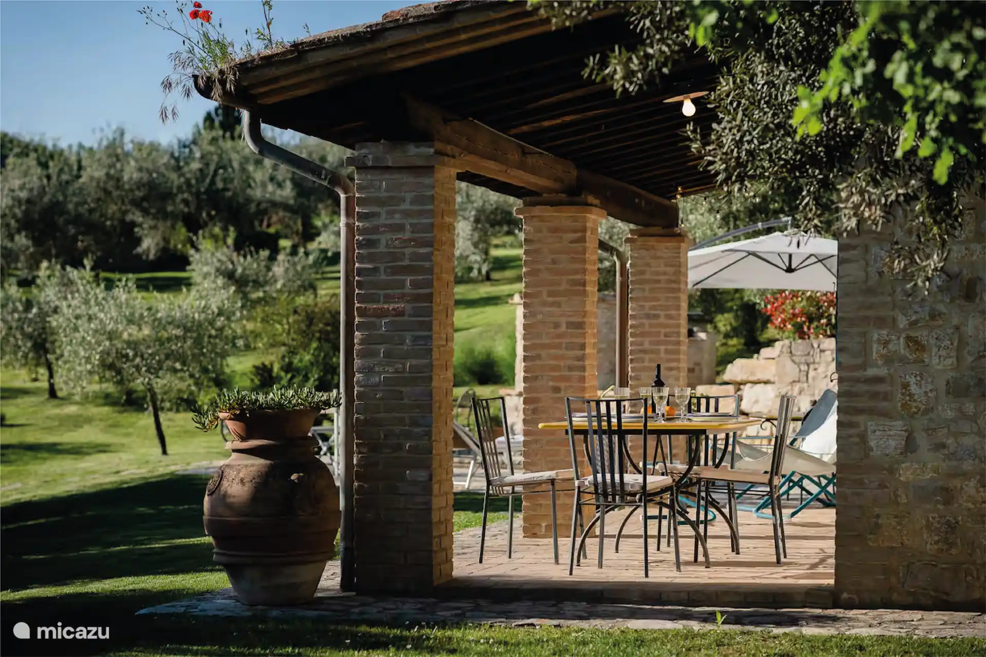 La zona de la piscina está equipada con tumbonas, mesa y sillas.