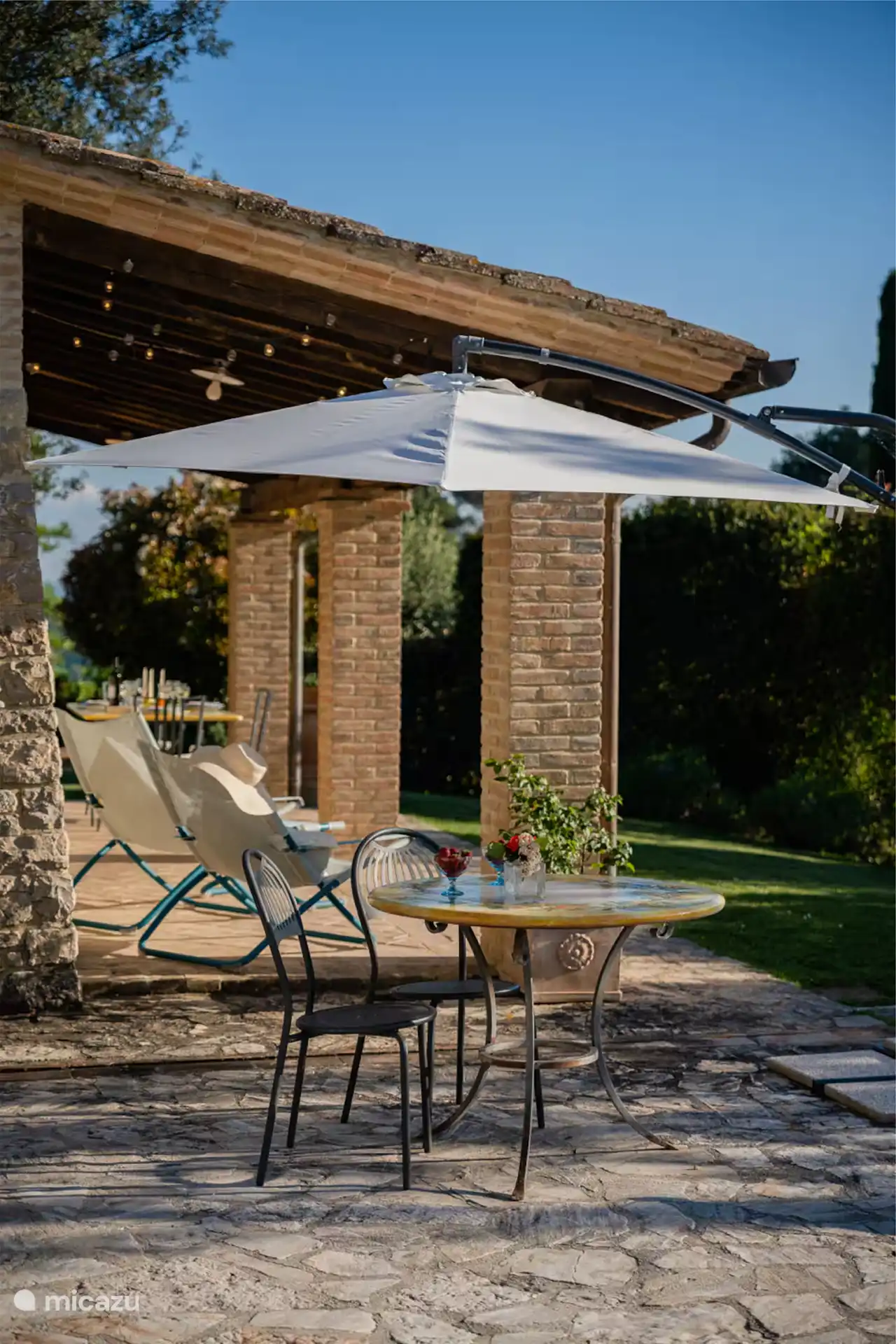 La zona de la piscina está equipada con tumbonas, mesa y sillas.