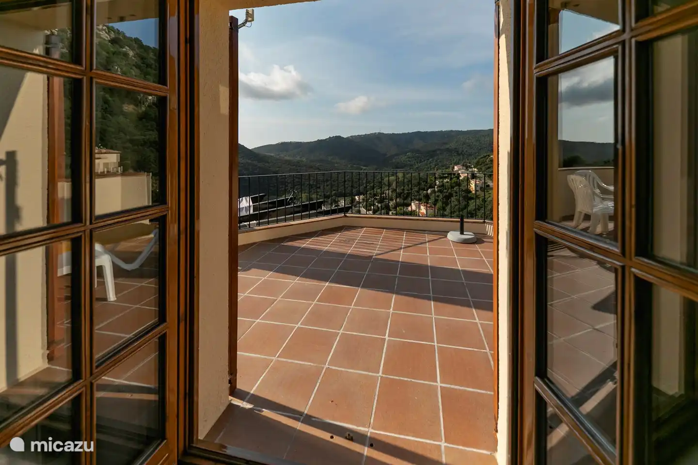 uitzicht vanuit een slaapkamer naar dakterras en bergen