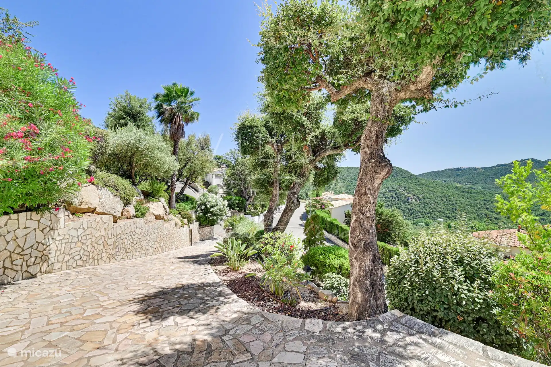 oprit van straat naar de villa toe