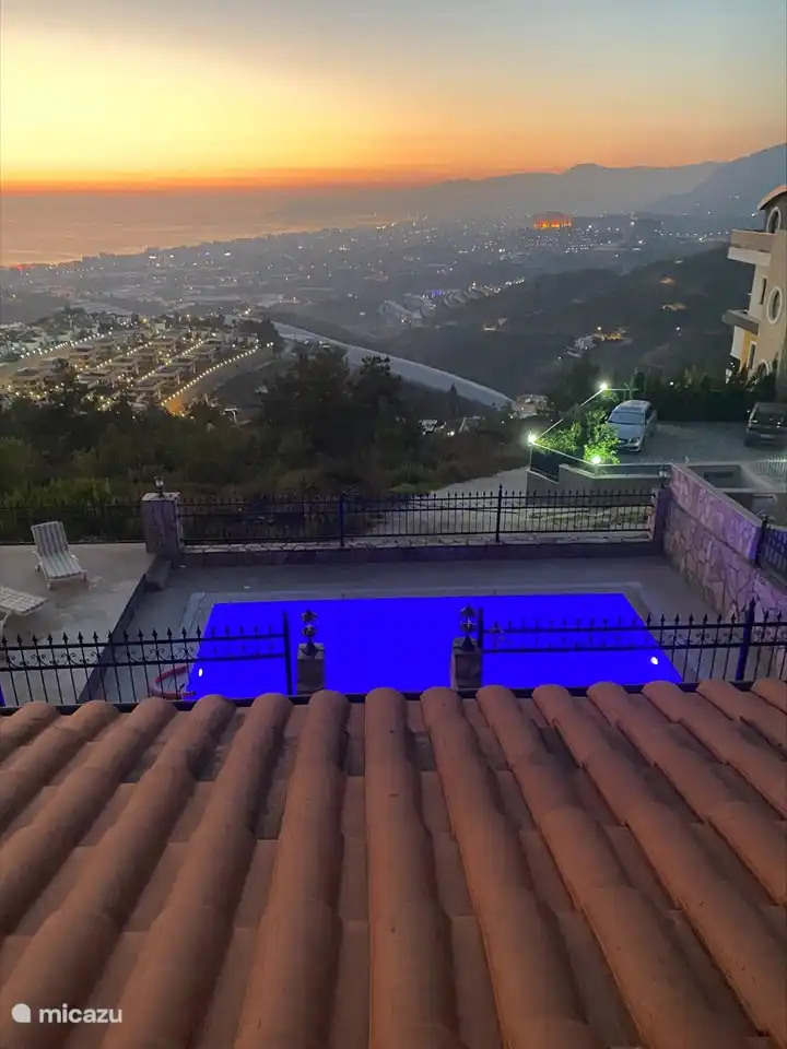 Vista nocturna con piscina iluminada.