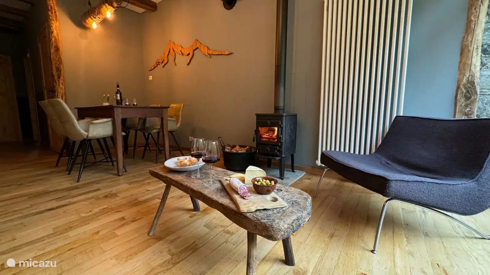 Geniet van een sfeervol verblijf in Appartement Stella in Valsesia, Piemonte. De gezellige woon- en eetkamer met houtkachel, comfortabele zithoek en warme inrichting is ideaal om te ontspannen.
