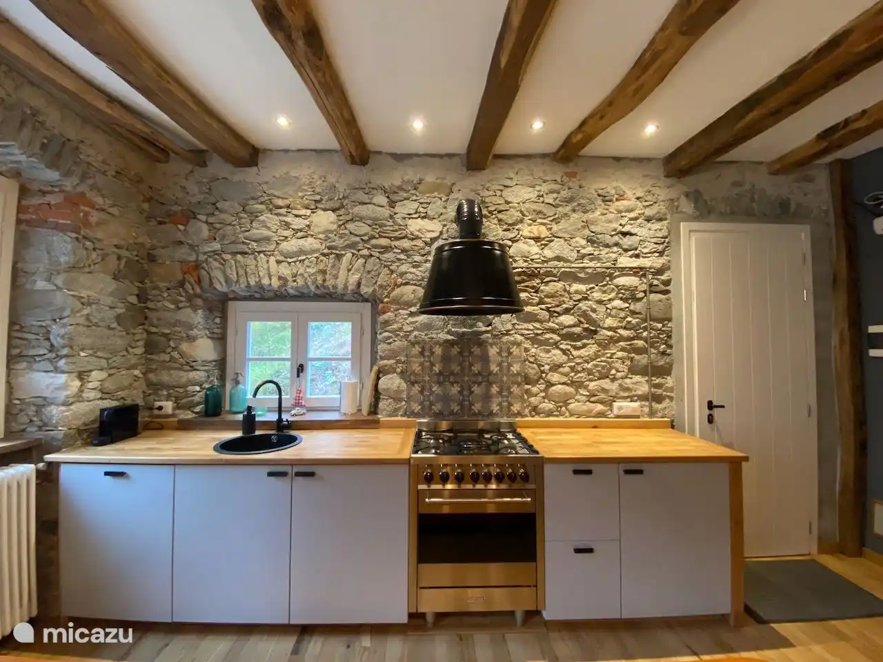 Keuken met 5 pits gasfornuis met oven, vaatwasser, afzuigkap, koel- vriescombinatie en Nespresso apparaat
