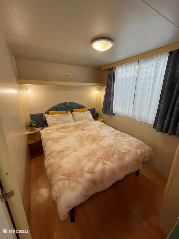 Cama doble con almohadas y edredones y amplio armario