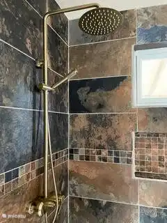 Es gibt eine schöne Dusche in einem großen Raum mit fließend heißem und kaltem Wasser