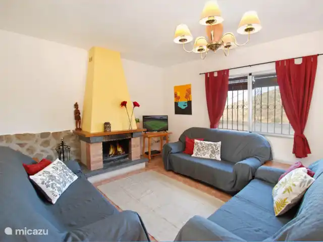 villa en España, Costa del Sol, Comares – villa el deseo El salón es acogedor con chimenea y chimenea para el invierno. Hay una TV inteligente y una amplia zona de estar.