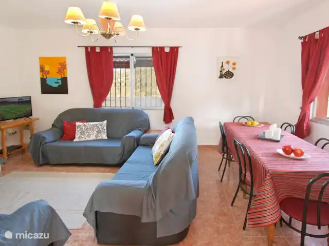 villa en España, Costa del Sol, Comares – villa el deseo El salón tiene una mesa de comedor con sillas. Todas las ventanas tienen mosquiteras y persianas.