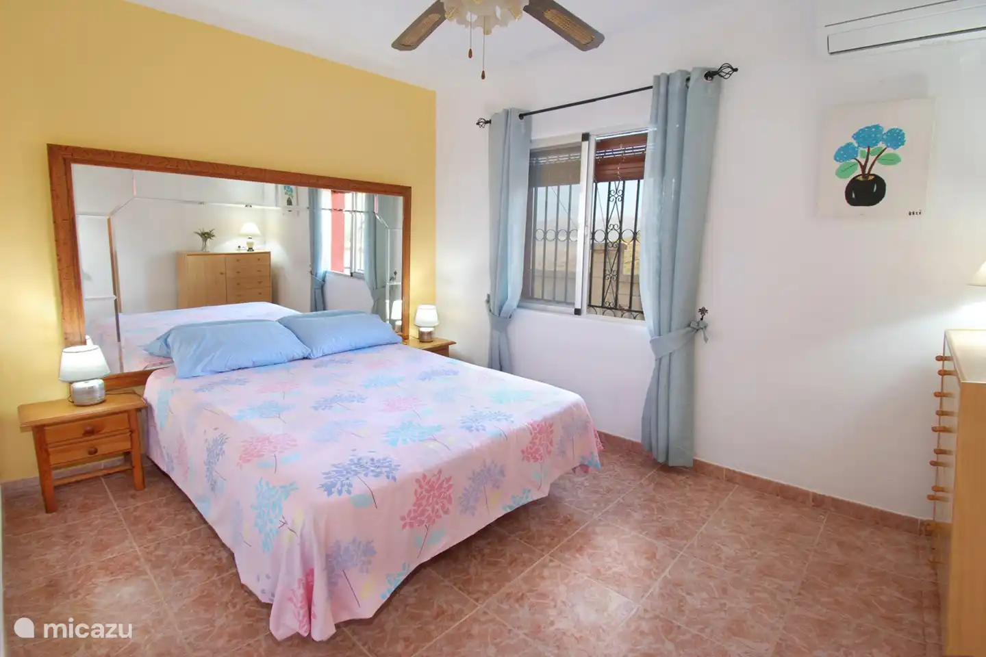 The large bedroom with mirror wall also has air conditioning in addition to a ceiling fan. 