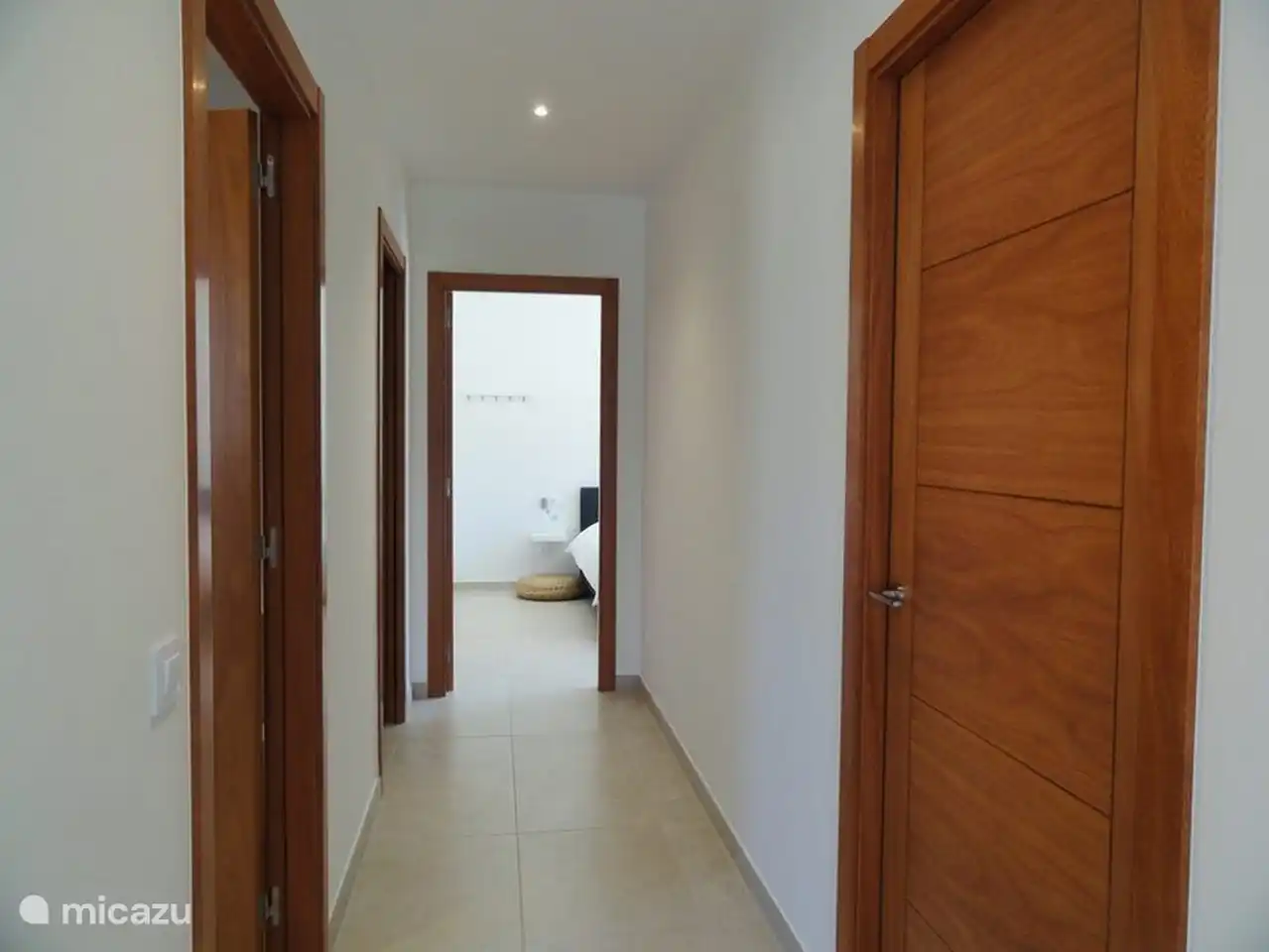 le couloir du salon où se trouvent la chambre, les salles de bains et la buanderie du rez-de-chaussée,