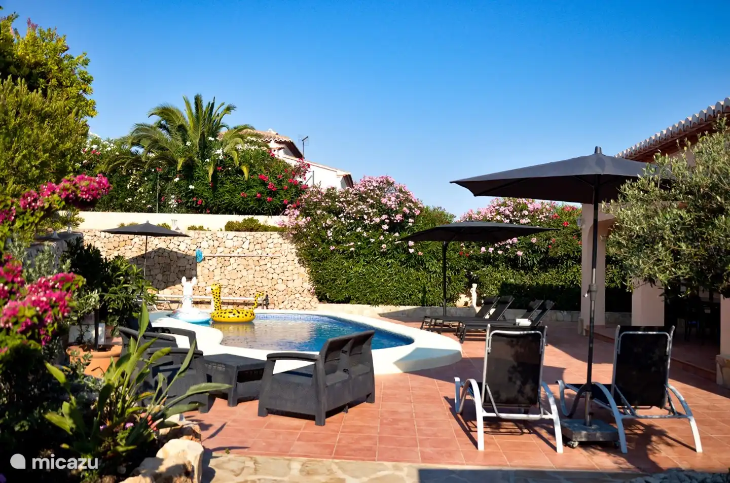 Die Oleander im Garten blühen üppig, was dem Garten/der Terrasse ein fröhliches Aussehen verleiht. Der Name des Hauses weist darauf hin.