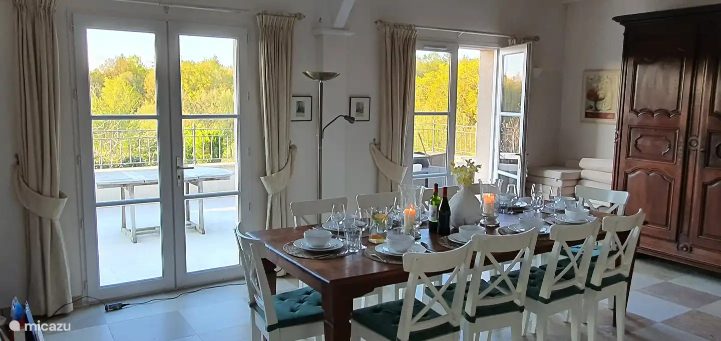 Esszimmer mit gedecktem Tisch und Blick auf Terrasse und Garten/Golfplatz