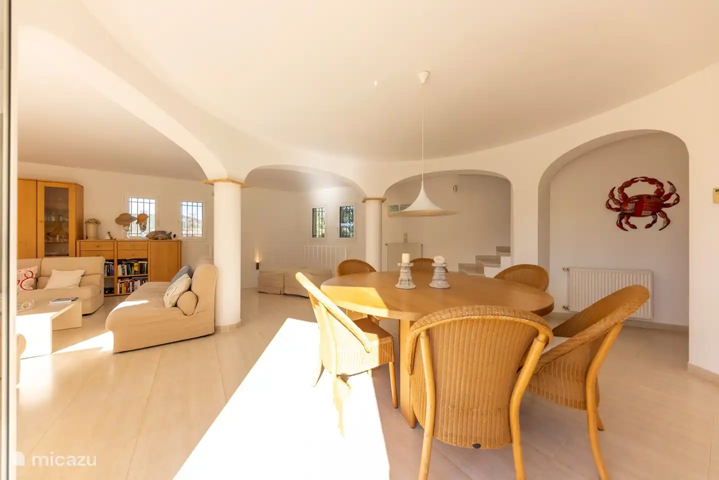 salon spacieux avec escalier menant aux chambres et escalier menant à la porte d'entrée de la villa