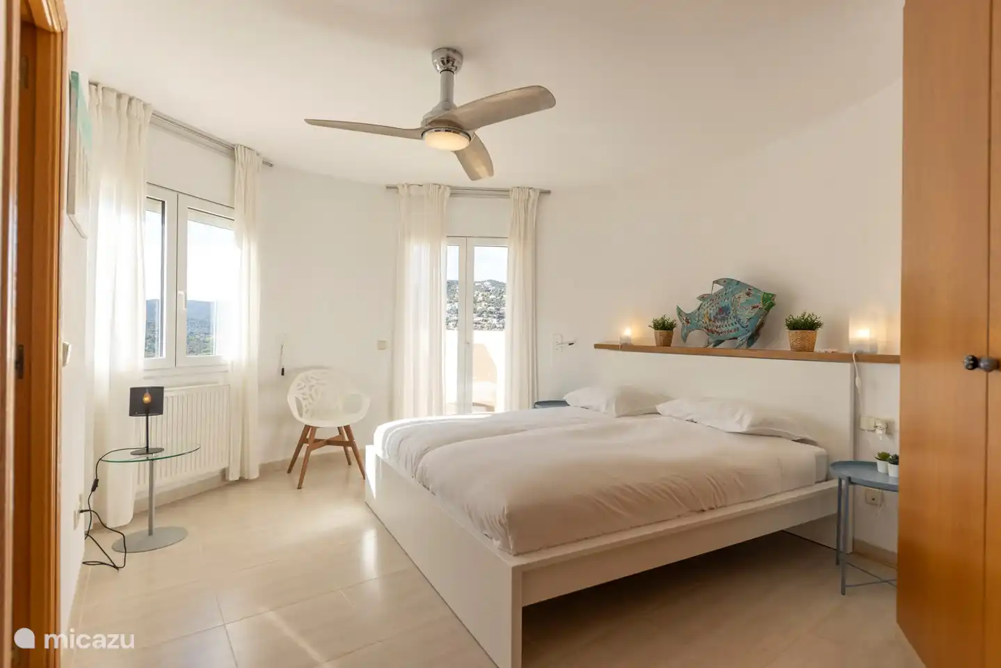 chambre à l'étage, avec une salle de bain attenante, un ventilateur et des portes-fenêtres donnant sur le balcon (avec moustiquaire contre la vermine)