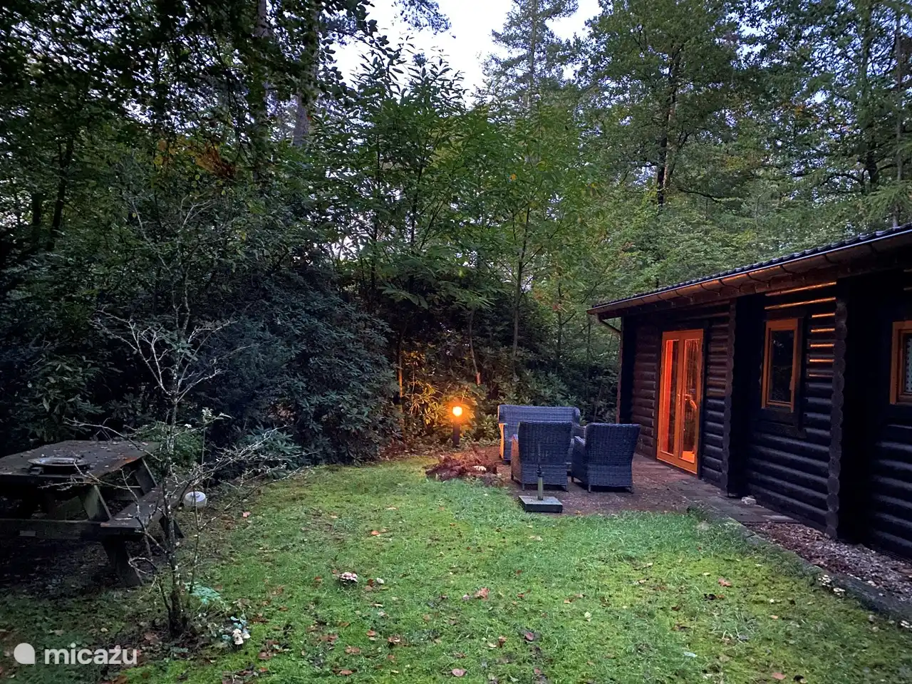 Jardín arbolado con mesa de picnic