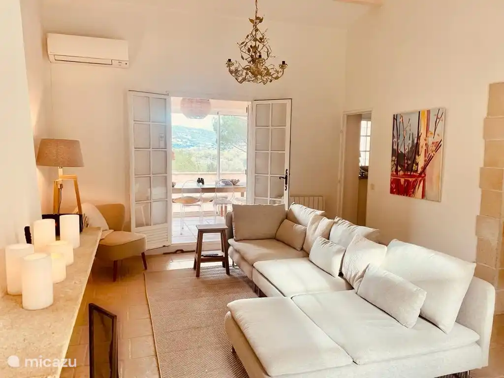 Wohnzimmer mit Lounge-Sofa, Klimaanlage, Kamin, TV (Chromecast) auf der Nordseite Zugang zum Balkon über Loggia, auf der Südseite Zugang zur Terrasse