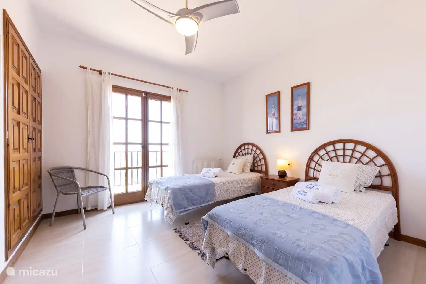 Bedroom with twin beds and patio doors leading to a balcony with stunning views,