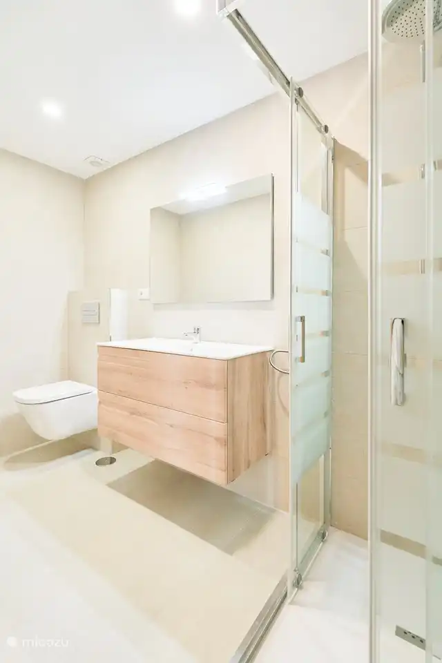 New bathroom with shower and toilet.