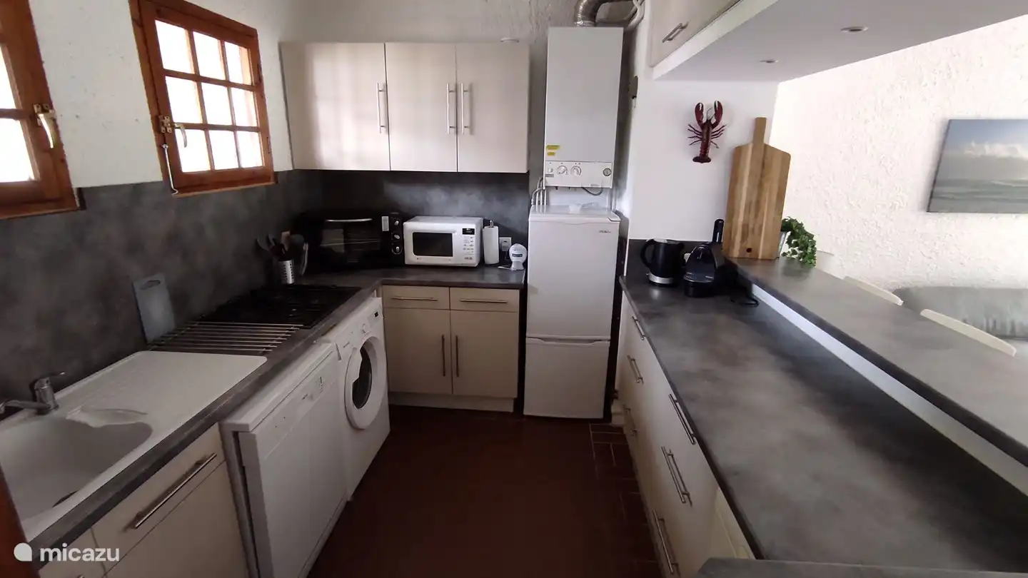 La cuisine ouverte est entièrement équipée, telle qu'une cuisinière à gaz à quatre feux, une machine Nespresso, un lave-vaisselle, un four, un micro-ondes, un lave-linge, un sèche-linge, etc.