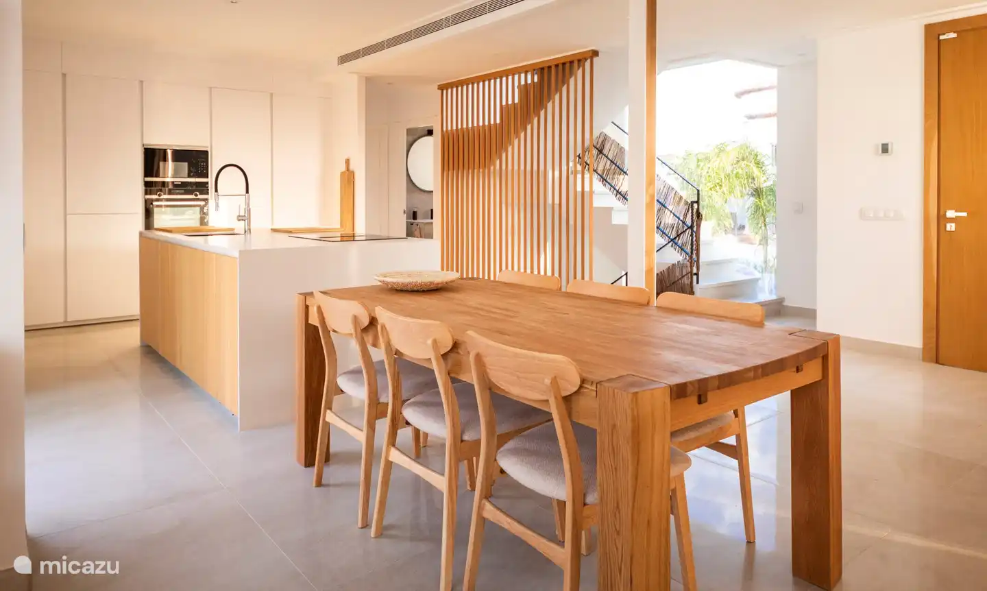 une cuisine ouverte lumineuse avec îlot de cuisson, équipée de tout le confort