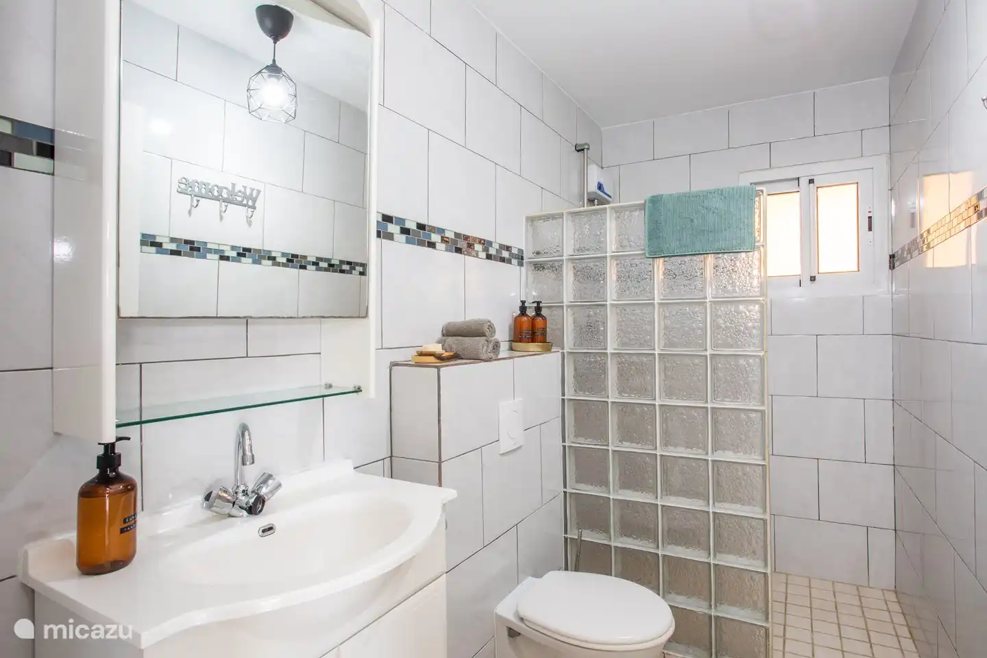 Badezimmer 1 mit Warmwasserdusche, Toilette und Waschbecken