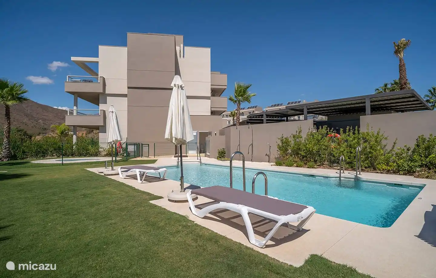 La piscine clôturée avec bassin pour enfants, transats et parasols