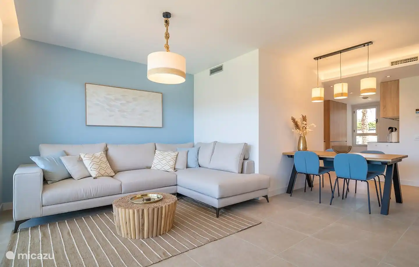 Le coin salon et la table à manger avec des chaises et la cuisine ouverte à l'arrière