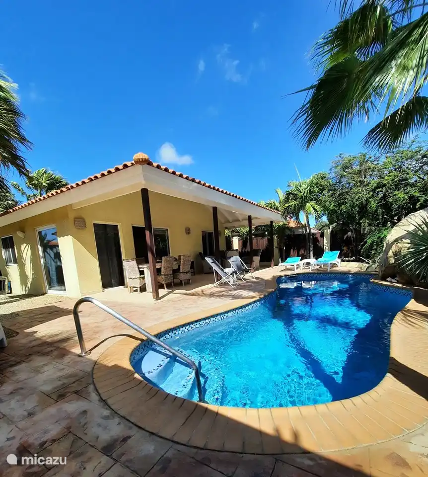 Porsche with large dining table, extra seating, 2 sun beds and two beach chairs, all with cushions. Also fan present