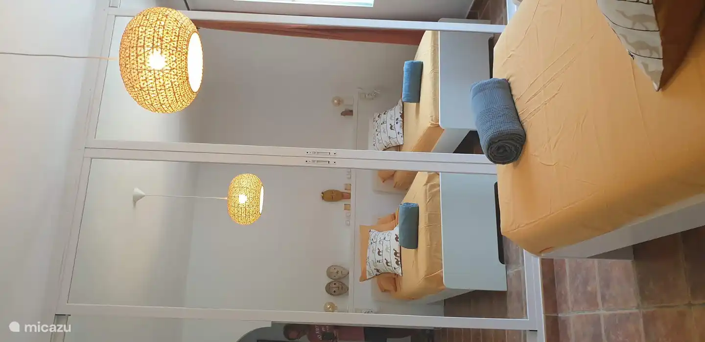 kamer met é enkele bedden en  spiegelkleerkast