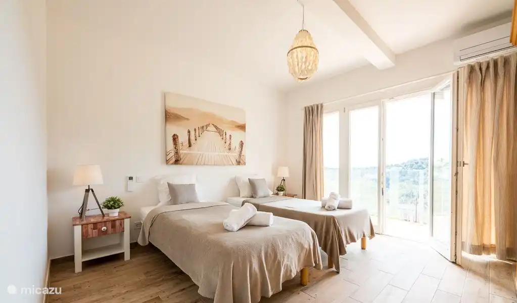 Very spacious bedroom with whisper-quiet air conditioning, patio doors to balcony with sea view.