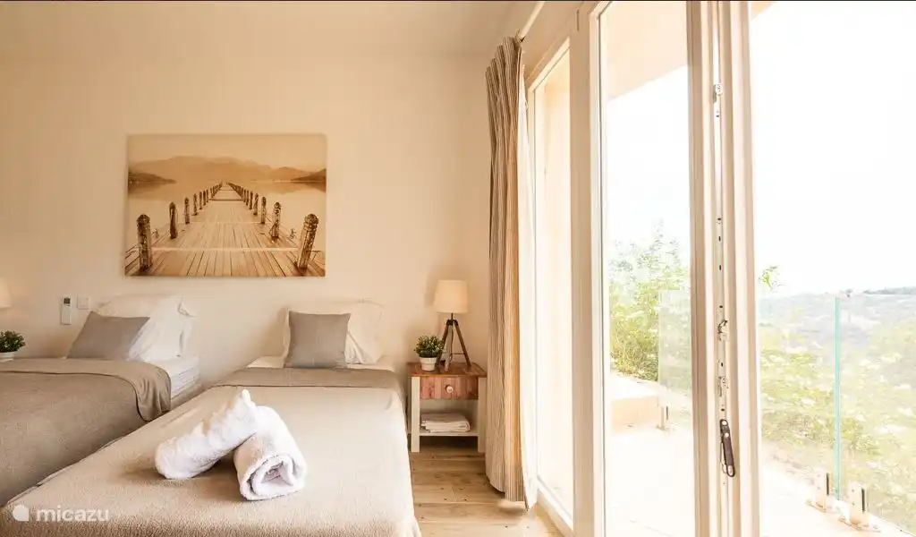 Very spacious bedroom with whisper-quiet air conditioning, patio doors to balcony with sea view.