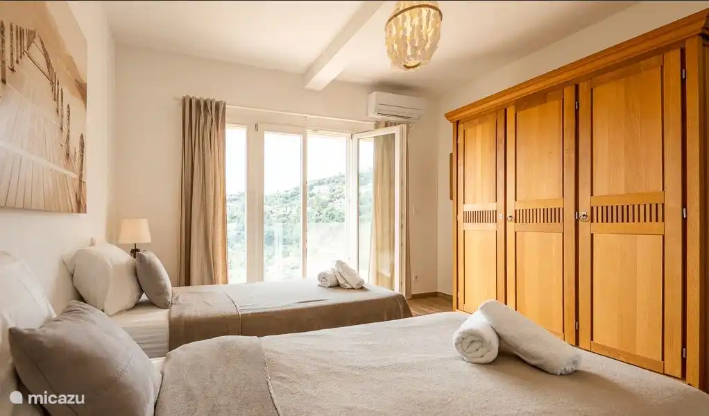 Very spacious bedroom with whisper-quiet air conditioning, patio doors to balcony with sea view.