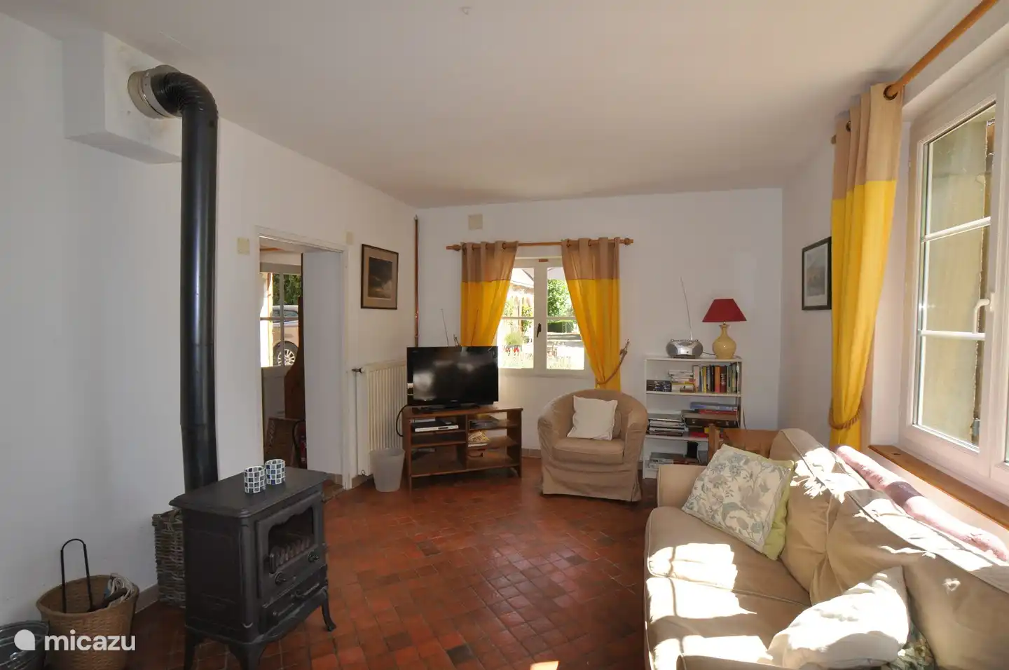 Séjour avec TV et lecteur DVD et poêle à bois.