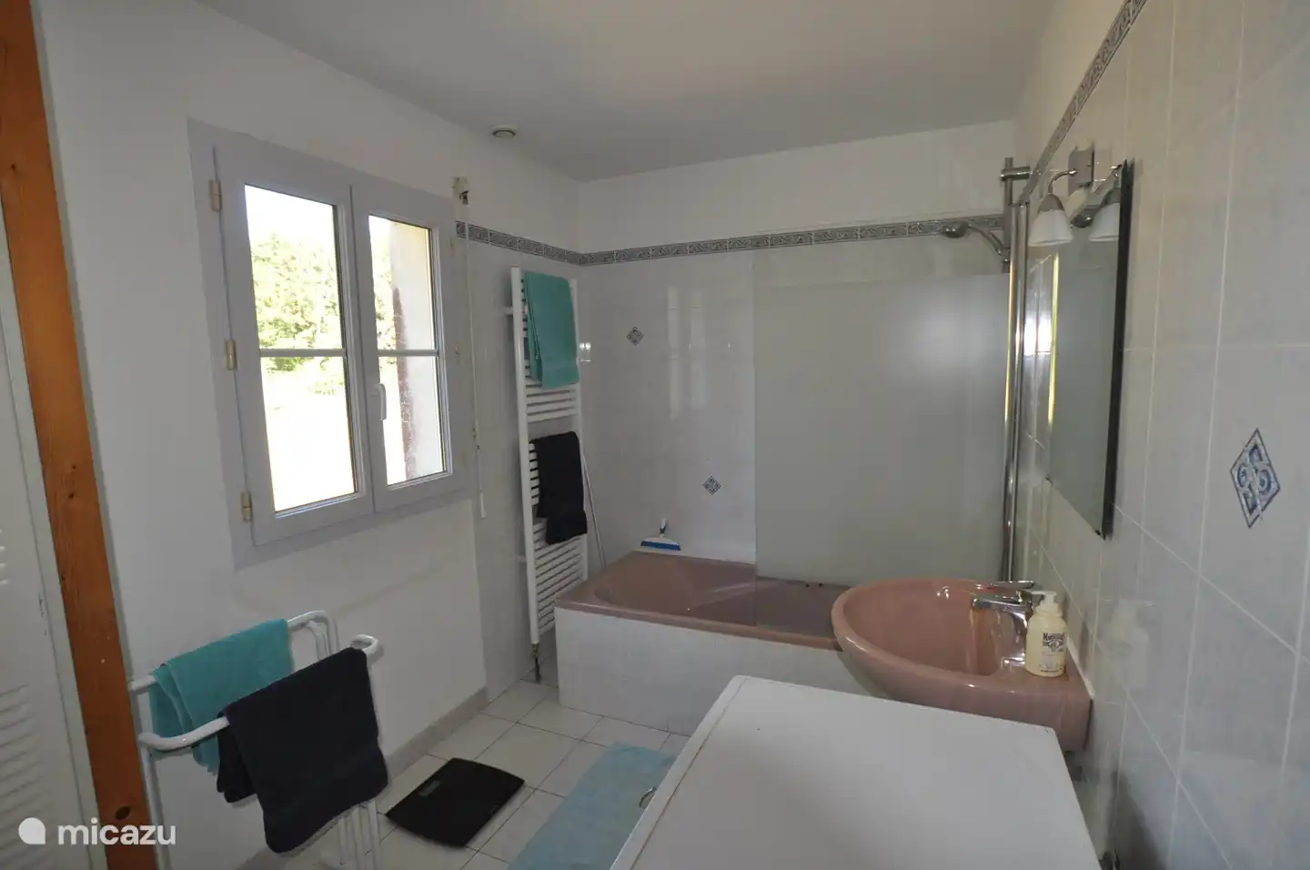 Salle de bain avec baignoire (avec douche) et machine à laver