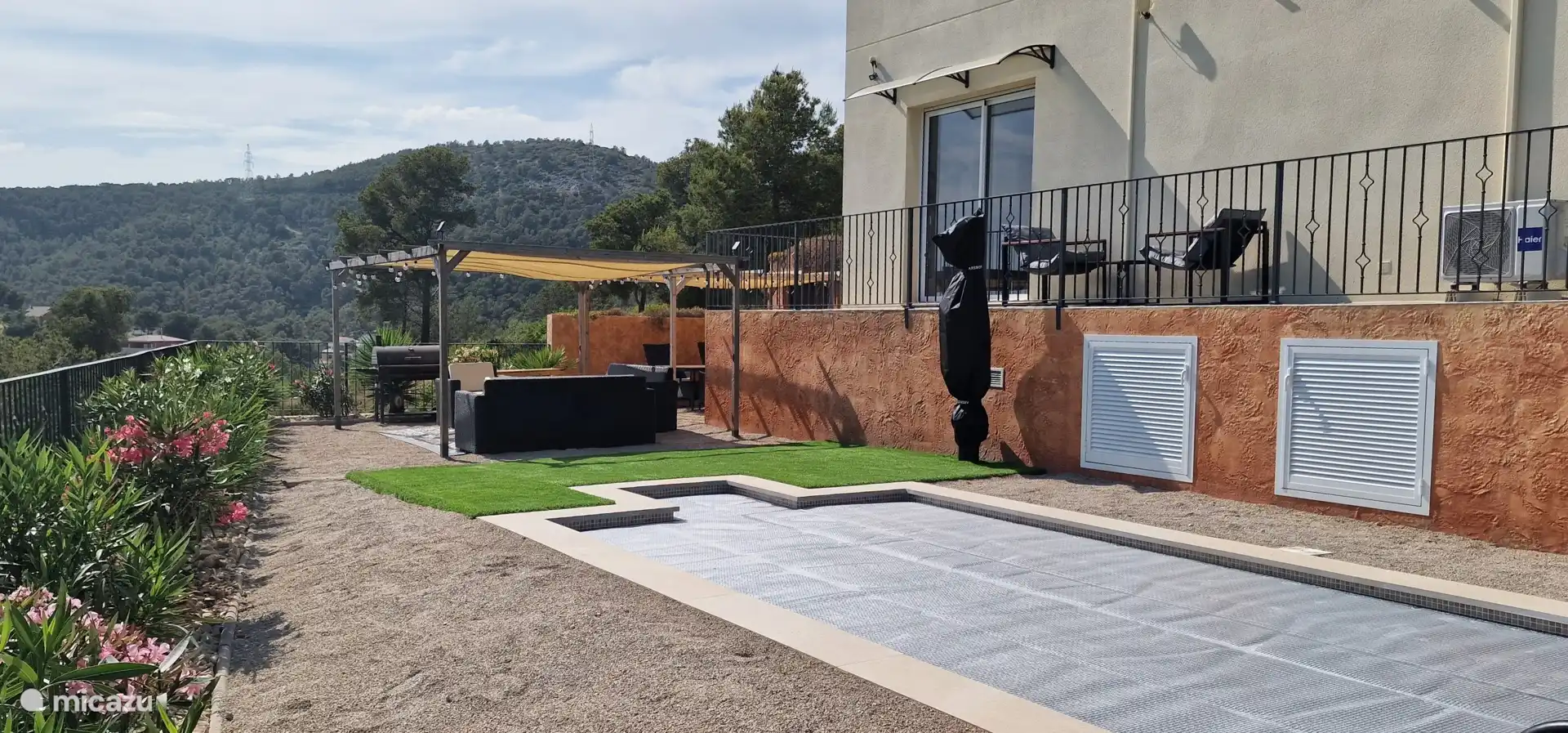 Piscina con cubierta t&#233;rmica y ducha exterior con cubierta.