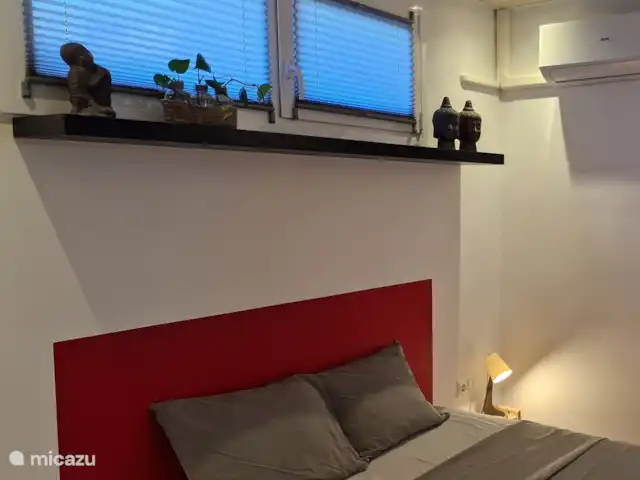 Location de Vacances Espagne, Barcelone, Canyelles, appartement - Villa Contenta Canyelles La chambre rouge un peu plus petite avec salle de bain attenante, moustiquaires, climatisation et une armoire intégrée avec porte coulissante en bois.